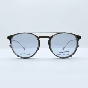 Brown-framed sunglasses with blue-tinted lenses resting on a white surface; lens text reads 'Clip-On Available' and 'BRETT Neo Heroes'—product shot for eyewear.