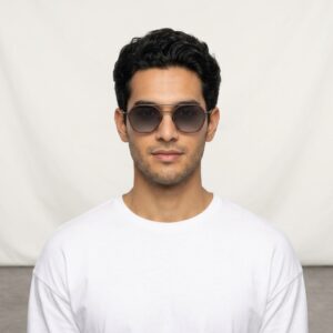 Young man with dark hair wearing sunglasses and a white T-shirt, facing the camera in a neutral setting.